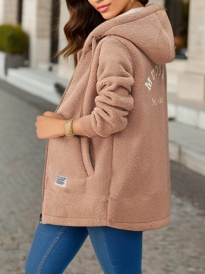 Delphine teddy coat in a warm neutral tone, side view showing hood and back detail