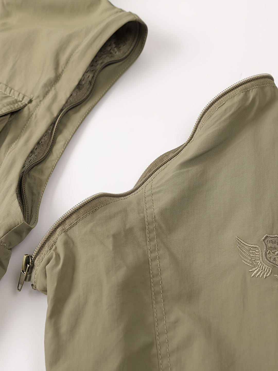 Close-up of Emerson cargo jacket shoulder zipper detail with embroidered emblem