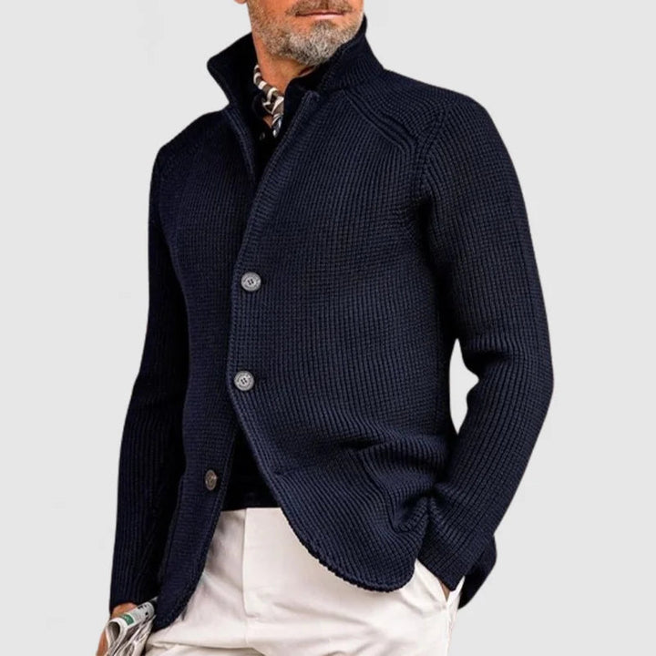 Man wearing navy stand collar button front knit cardigan, side angle