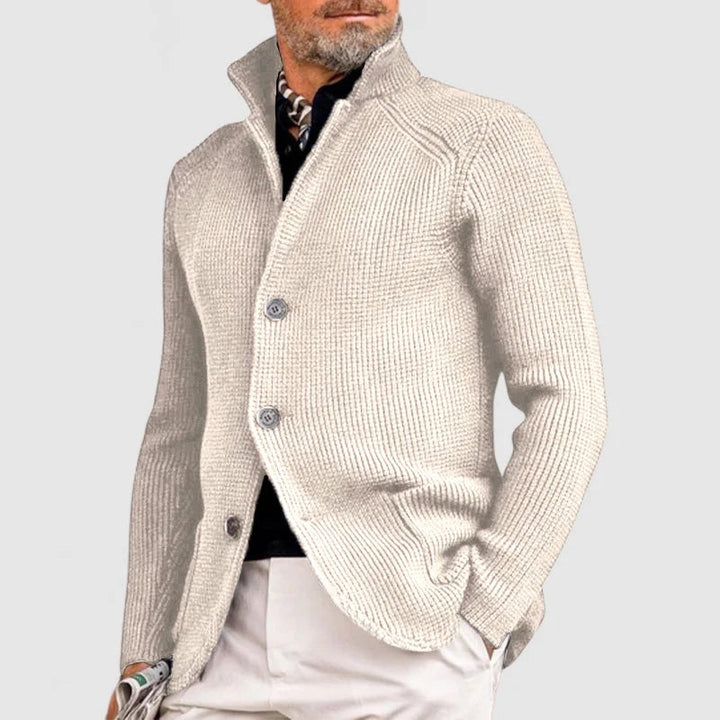 Man wearing beige stand collar button front knit cardigan, side view