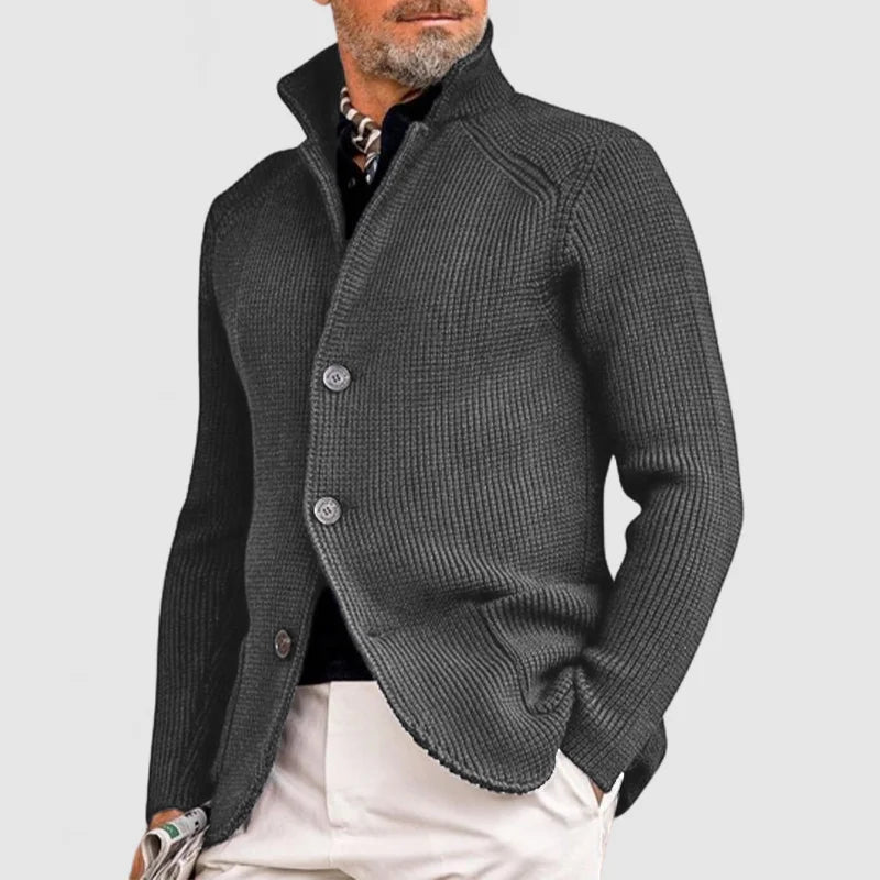 Man wearing charcoal grey stand collar button front knit cardigan, side view