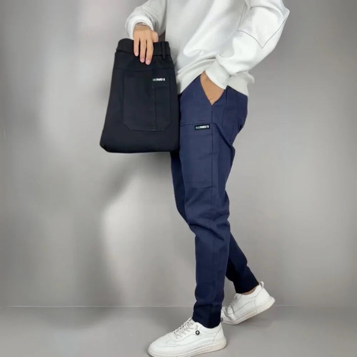 Julian cargo joggers shown in navy and black, side pose with bag