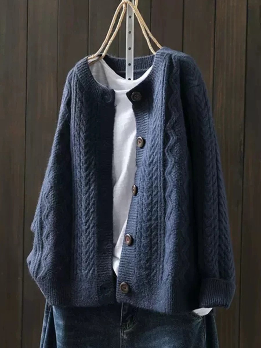 Marguerite oversized cable knit cardigan in navy blue, front view on hanger
