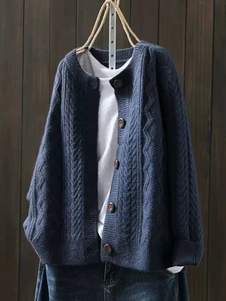 Marguerite oversized cable knit cardigan in navy blue, front view on hanger
