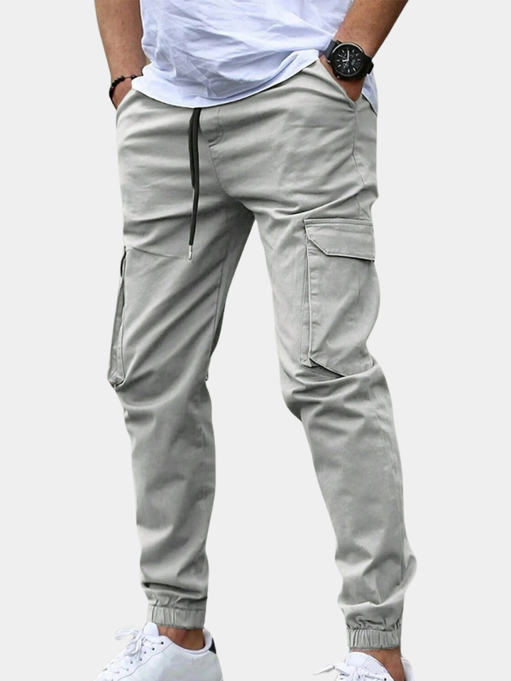 Ronan light gray cargo jogger pants, side view with hands in pockets