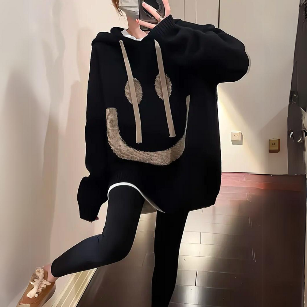 Thomasina oversized smiley hoodie in black, front view with kangaroo pocket