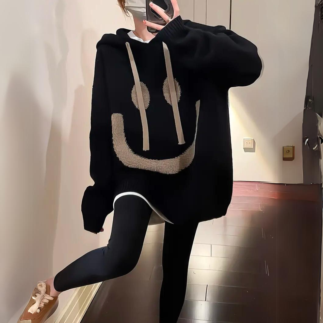 Thomasina oversized smiley hoodie in black, front view with kangaroo pocket